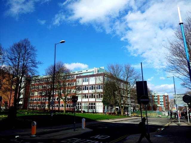 High school building exterior is pictured in a town or city landscape